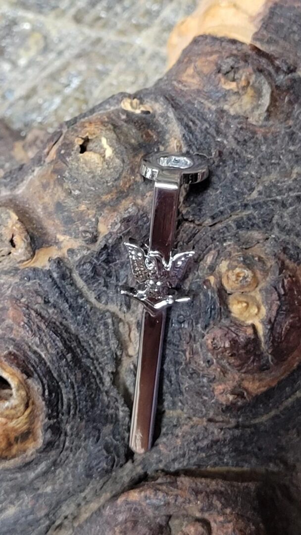 Silver nail with eagle design on wood