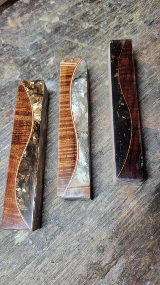 Artisan knife handles with unique wood designs.