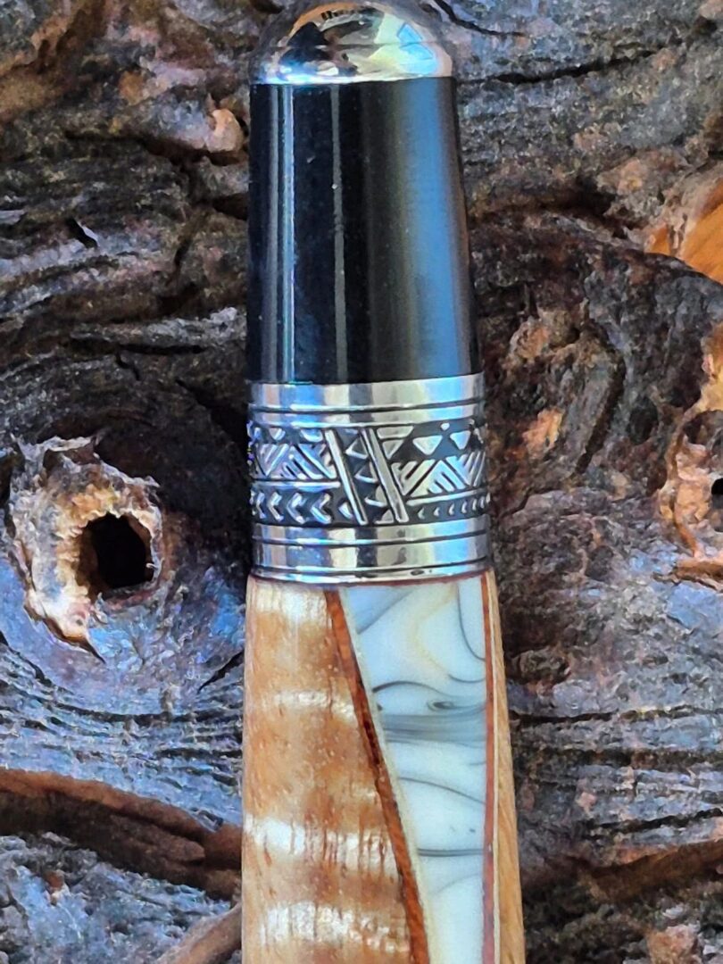 Decorative pen featuring intricate metalwork design.