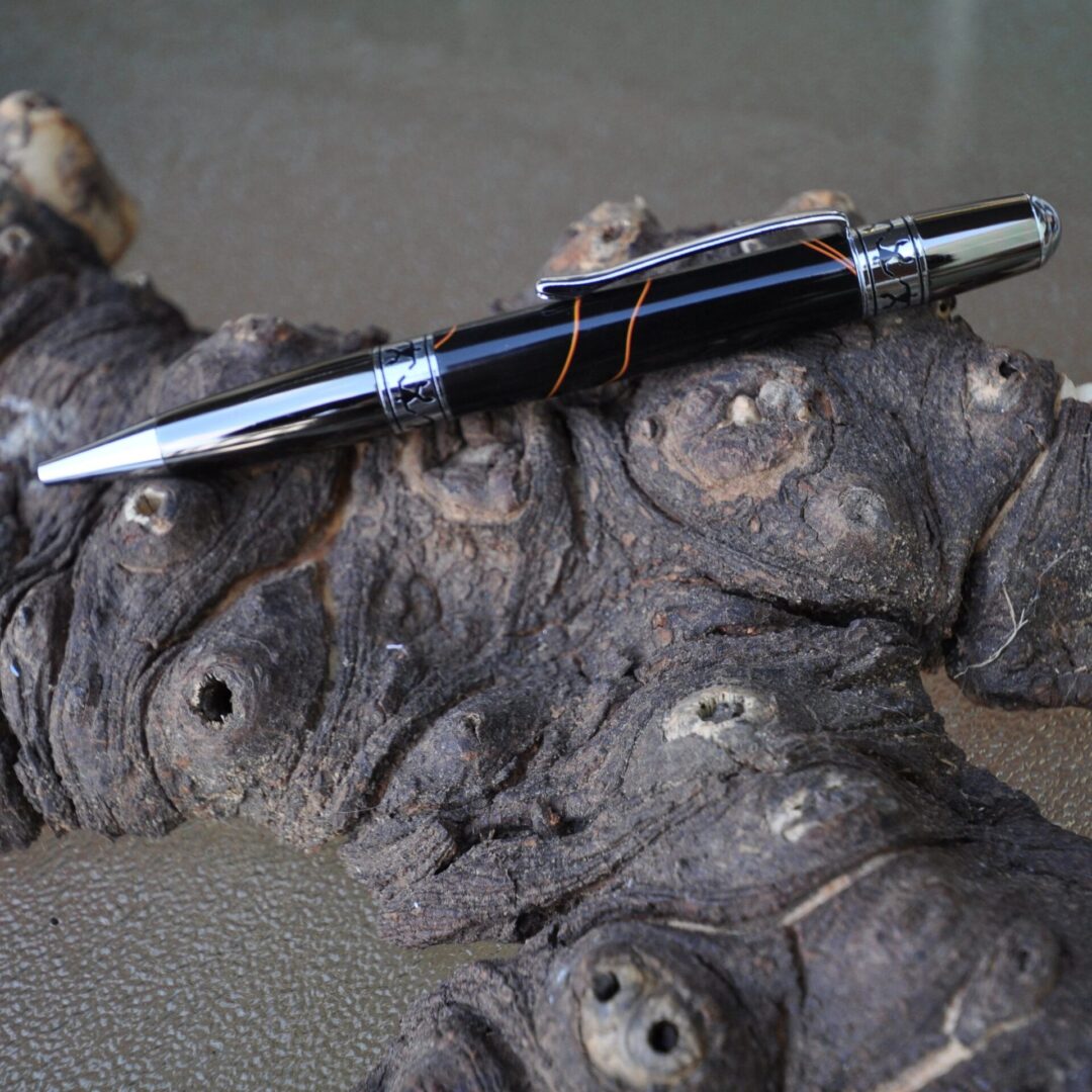 Black and silver pen displayed on wood