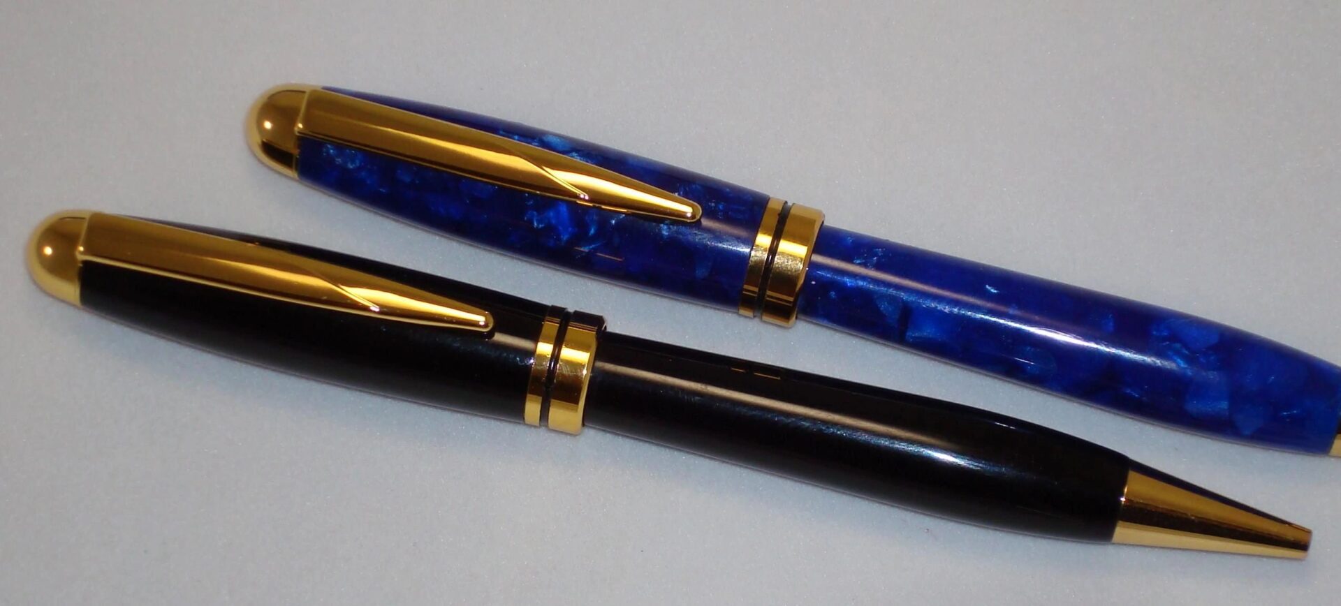 Blue and black pens with gold accents.