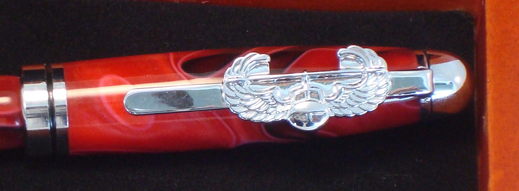 Red pen with silver winged emblem