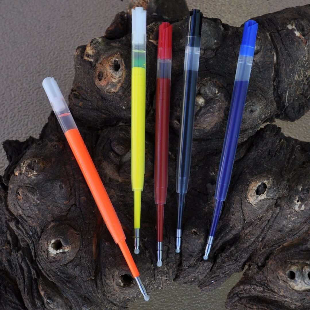 Assorted pen refills on tree bark