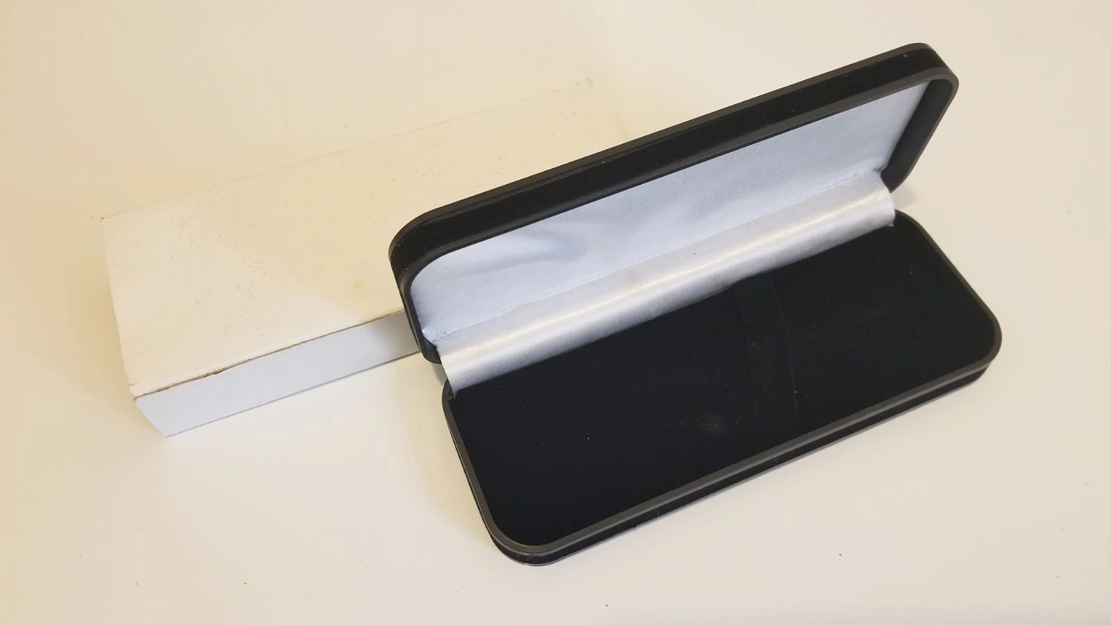 Empty black case with white box