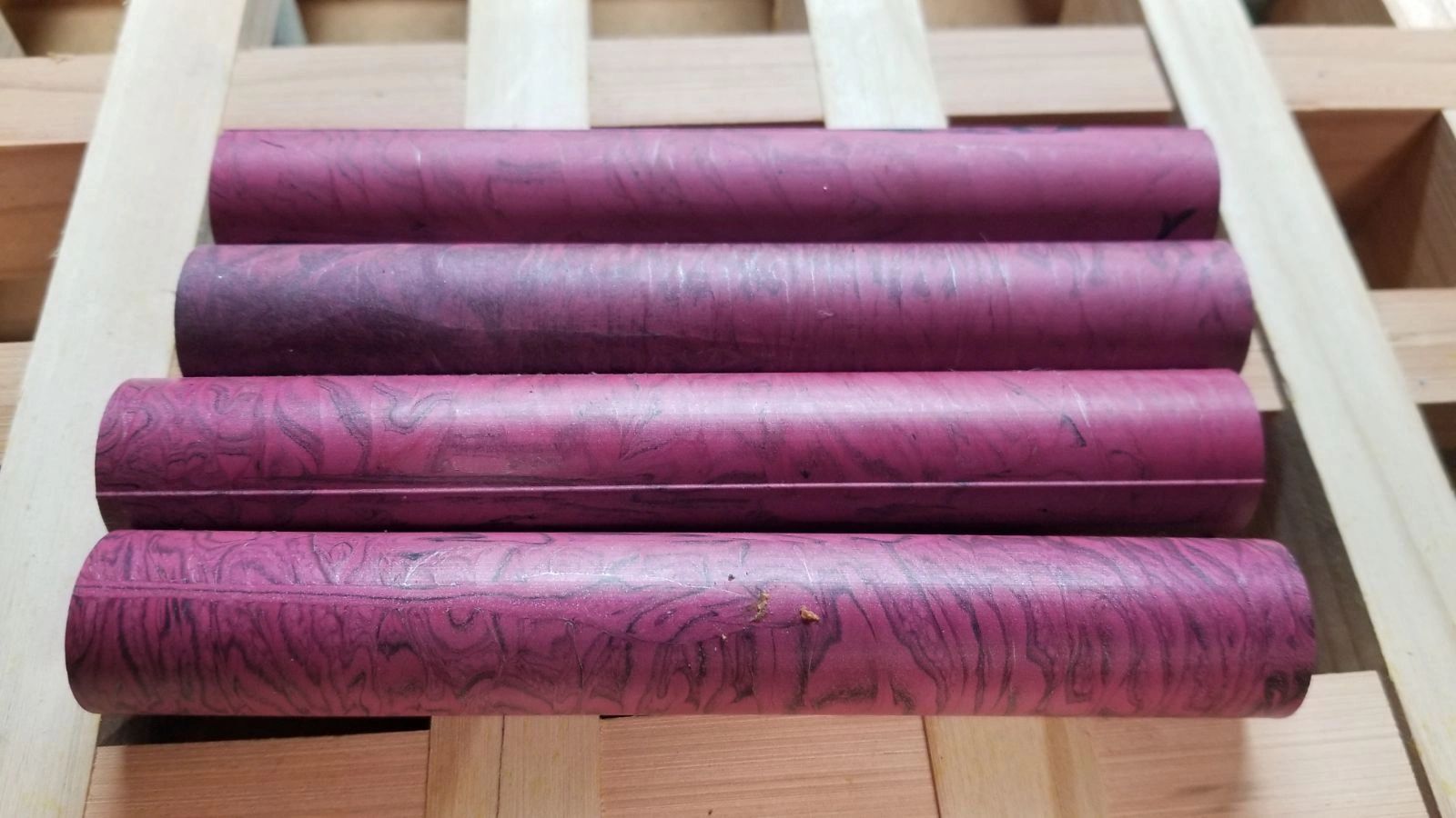 Four cylindrical wooden pieces in purple