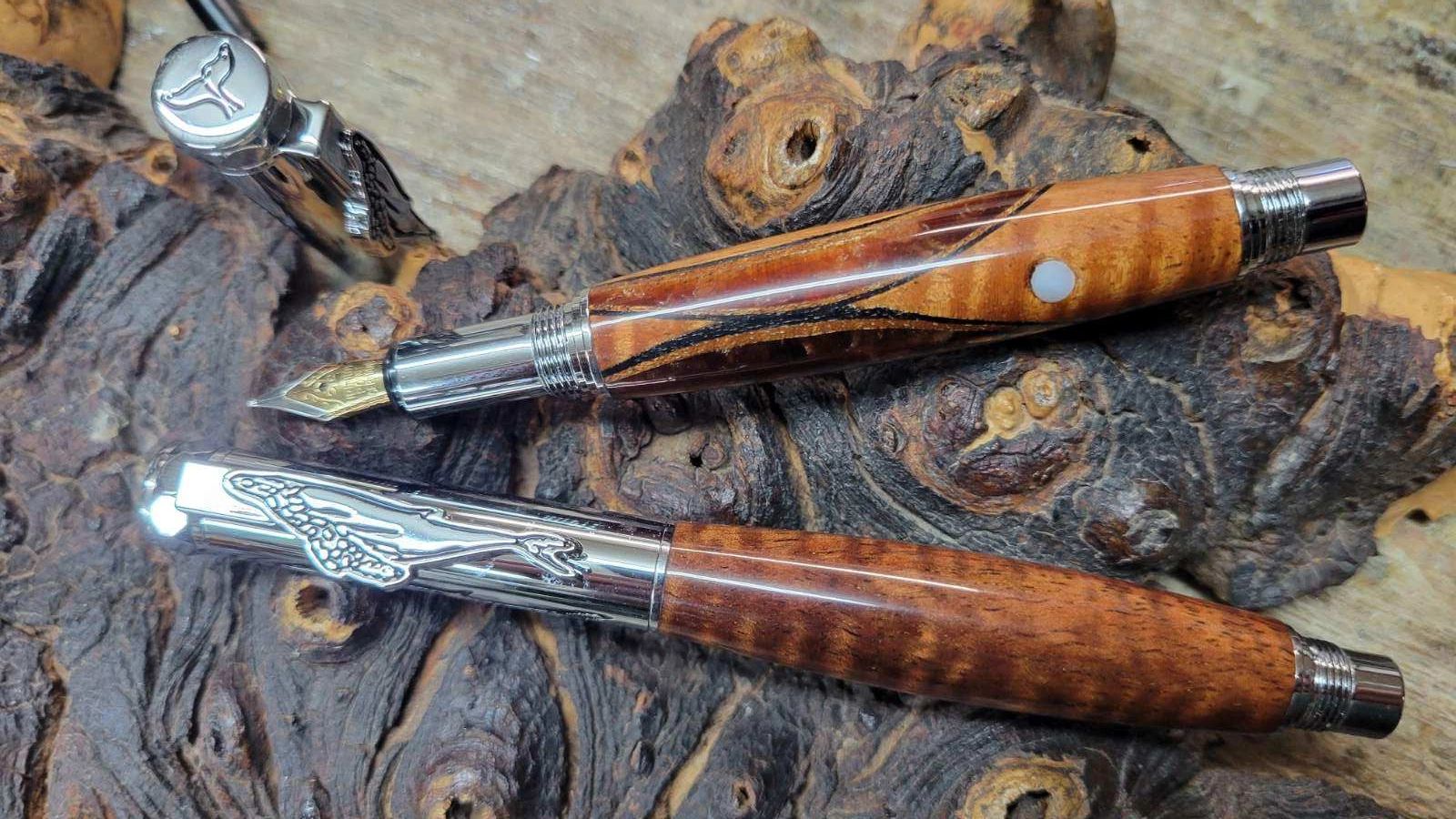 Wooden fountain pens on textured burl background